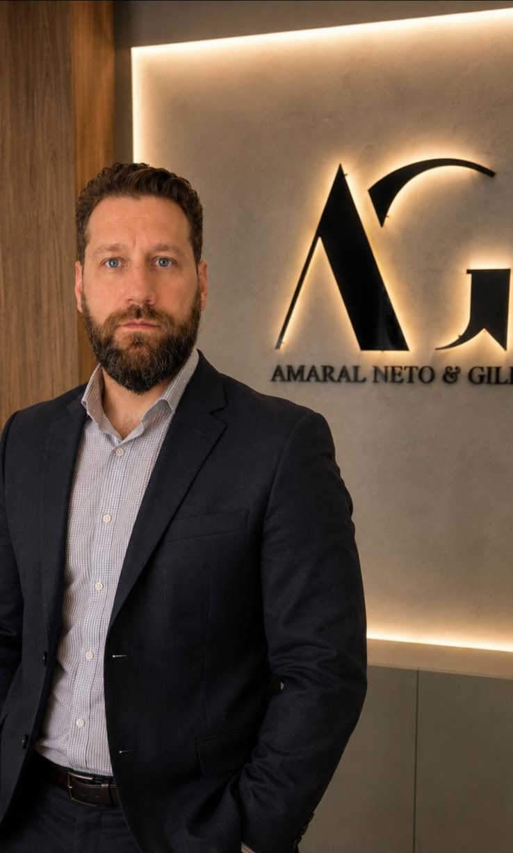 Hilton Amaral Neto, advogado sócio do Amaral Neto & Gill, em frente ao logotipo do escritório
